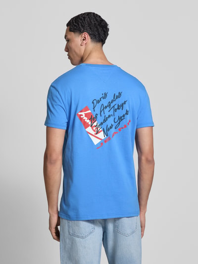 Männermodel trägt Regular Fit T-Shirt aus reiner Baumwolle von Tommy Jeans, unifarbenes Jersey mit Label Print, Ganzkörperansicht Rückansicht.