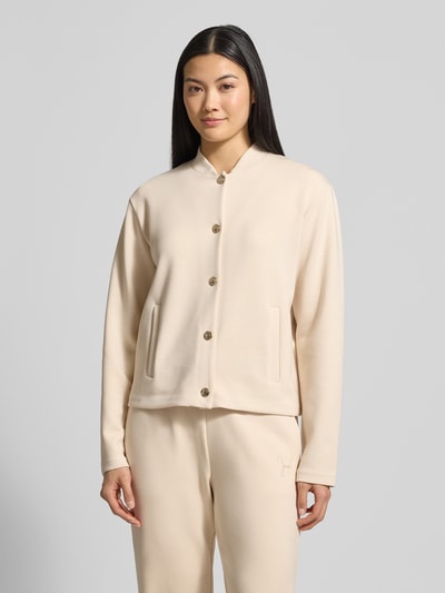 Frauenmodel trägt Sweatjacke mit Stehkragen Modell 'Tobina' von JOOP! im Regular-Fit, Material-Mix mit Modal-Anteil, Eingrifftaschen, Knopfleiste, helle Farbe, glatte Struktur, Ganzkörperansicht von vorne.