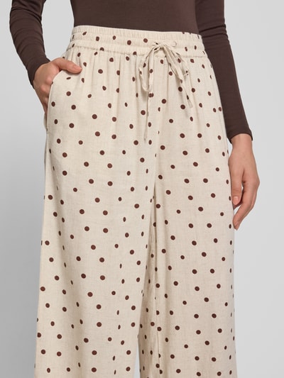 Frauenmodel trägt Gerade Hose aus Viskose-Leinen-Mix von PIECES in Beige mit braunen Punkten, lockere Textur, Nahaufnahme Oberkörper.