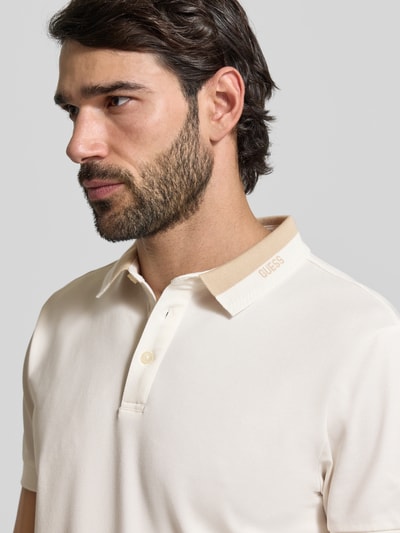 Męski model nosi Regular Fit Poloshirt mit Knopfleiste Modell 'PAUL' von GUESS, mieszanka bawełny z dodatkiem streczu, krój regular fit, długość tyłu w rozmiarze M: 69 cm, jasny kolor, gładka tekstura, zbliżenie na górną część ciała