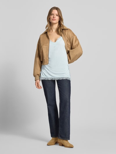 Vrouwenmodel draagt Regular Fit Top mit Spitzenbesatz van Gina Tricot in lichtblauw met kanten details, v-hals en verstelbare spaghettibandjes, regular fit, ruglengte maat S 47 cm. Volledige lichaamsvoorzijde.
