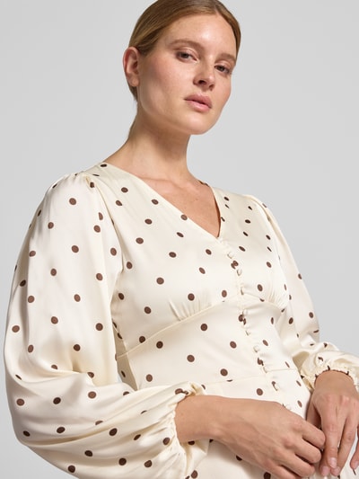 Frauenmodel trägt Slim Fit Minikleid mit durchgängiger Knopfleiste Modell 'Mabel' von Neo Noir, cremefarben mit braunen Punkten, elastischer Material-Mix, langärmelig, V-Ausschnitt, Nahaufnahme Oberkörper