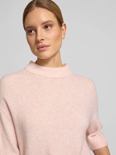 Frauenmodel trägt Strickshirt mit überschnittenen Schultern Modell 'Pafinna' von OPUS in zartem Rosa, gerippte Abschlüsse, Nahaufnahme Oberkörper.