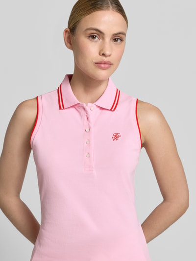 Frauenmodel trägt Slim Fit Poloshirt aus Baumwoll-Mix von Tommy Hilfiger in Two-Tone-Optik mit Logo-Stitching und Kontrast-Nähten, Nahaufnahme Oberkörper.