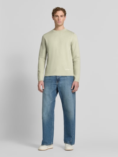 Męski model nosi sweter z mieszanki wiskozy z dodatkiem streczu Samsøe Samsøe Pullover aus Viskose-Mix mit Label-Stitching Modell 'MATT' krój slim fit, okrągły dekolt, wyhaftowane logo, długość tyłu 67 cm, długość rękawów 68 cm, widok całej sylwetki z przodu