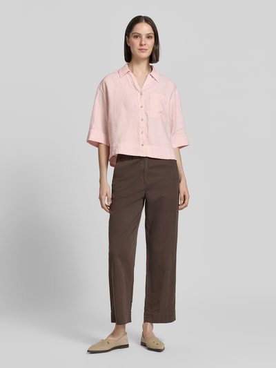 Frauenmodel trägt Regular Fit Leinenbluse mit Brusttasche Modell 'Flippa' von OPUS in Rosa, reine Leinenqualität, Hemdblusenkragen, V-Ausschnitt, Ganzkörperansicht von vorne.