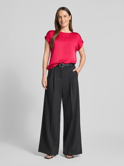 Modelka nosi T-Shirt mit Rundhalsausschnitt Modell 'ELLETTE' od Vila, różowy odcień, luźny krój, mieszanka wiskozy i elastanu, długość tyłu 57 cm, widok całej sylwetki z przodu.