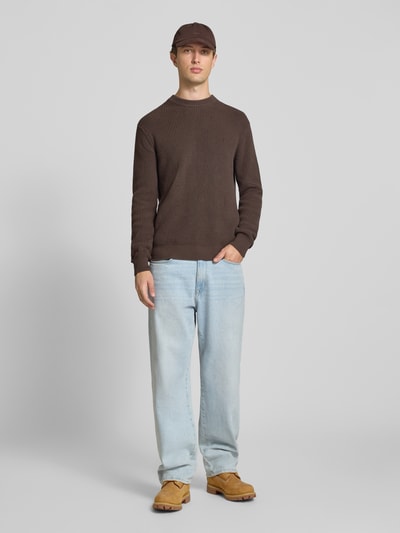 Männermodel trägt Slim Fit Pullover aus reiner Baumwolle in Strick-Optik von Replay, braun mit Rundhalsausschnitt, Ganzkörperansicht von vorne.