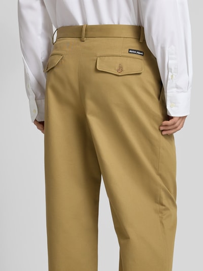 Männermodel trägt Relaxed Fit Stoffhose aus Baumwolle von MAISON KITSUNÉ in Beige mit Gesäßtaschen, Rückansicht, Detailaufnahme. Innenbeinlänge 72 cm, Bundweite 43 cm.