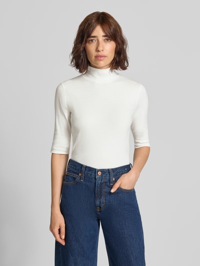 Frauenmodel trägt Slim Fit T-Shirt mit Rollkragen von Marc Cain in Weiß, elastischer Baumwoll-Mix, Halbarm, Ganzkörperansicht von vorne.