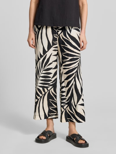 Frauenmodel trägt Wide Fit Stoffhose aus Viskose-Mix Modell 'Life' von Mango mit floraler Allover-Print, verkürzt, elastischer Bund, Nahaufnahme Unterkörper.
