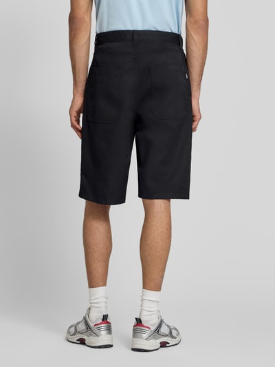 Männermodel trägt Bermudas mit Eingrifftaschen von REVIEW, Material-Mix mit Baumwoll-Anteil, Regular-Fit, Gesäßtaschen, Ganzkörperansicht Rückansicht.