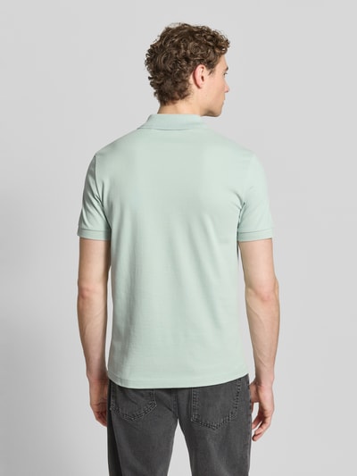 Männermodel trägt Regular Fit Poloshirt aus Baumwoll-Mix Modell 'PASSENGER' von BOSS Orange, Optik: Unifarben, Ganzkörperansicht Rückansicht.