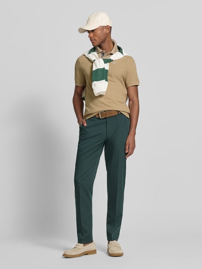 Männermodel trägt Regular Fit Poloshirt aus reiner Baumwolle von Barbour, Optik: Unifarben, Piqué, Label-Stitching-Applikation, Ganzkörperansicht von vorne