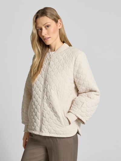 Vrouwenmodel draagt Regular Fit Steppjacke met Eingrifftaschen Modell 'Bingo' van FREE/QUENT in licht beige, gewatteerde structuur, staande kraag, ritssluiting, elastische mouwuiteinden, maat S: ruglengte 63 cm, schouderbreedte 43 cm, borstwijdte 51 cm, mouwlengte 64 cm, geheel vooraanzicht.