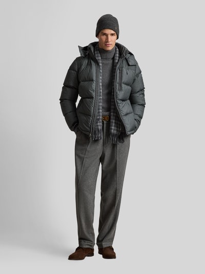 Männermodel trägt Regular Fit Daunenjacke mit Logo-Stitching von Polo Ralph Lauren in Anthrazit, kombiniert mit grauer Hose; Ganzkörperansicht von vorne. Herren Daunenjacke von Polo Ralph Lauren.