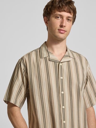 Männermodel trägt Regular Fit Freizeithemd mit Reverskragen Modell 'HOWIE' von Redefined Rebel, Allover-Look, Reine Baumwolle, Nahaufnahme Oberkörper. Rückenlänge 60 cm, Schulterbreite 60 cm, Ärmellänge 30 cm, Label-Detail.