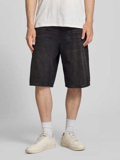 Männermodel trägt Jeansshorts mit Eingrifftaschen von REVIEW in Schwarz, Relaxed Fit, Used-Look, Nahaufnahme Oberschenkel, reine Baumwolle.