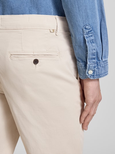 Mężczyzna model nosi beżowe chinosy Straight Fit Chino mit Eingrifftaschen Modell 'Vance' von Jack & Jones, mieszanka bawełny, wpuszczane kieszenie, kieszeń z tyłu, zapięcie na guzik i zamek błyskawiczny, szerokość w rozmiarze 32/32: 43 cm, długość wewnętrzna nogawki: 67 cm, detailaufnahme tylnej części spodni.