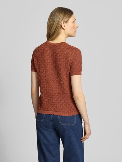 Modelka nosi Strickshirt mit Lochstickerei von Jake*s Collection, mieszanka bawełny, prosty krój, okrągły dekolt, rękaw o dł. 1/2, haft angielski, długość tyłu w rozmiarze S: 52 cm, długość rękawów w rozmiarze S: 21 cm, odcienie rdzawego i niebieskiego, widoczna faktura, całkowity widok z tyłu.