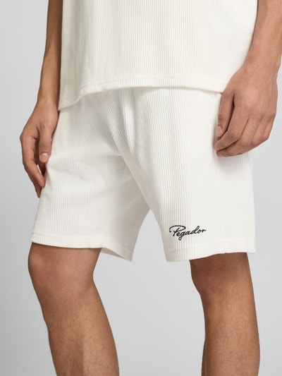 Männermodel trägt Shorts mit Logo-Stitching und elastischem Bund von Pegador in Weiß, Feinripp, Reine Baumwolle, Nahaufnahme Oberschenkel.