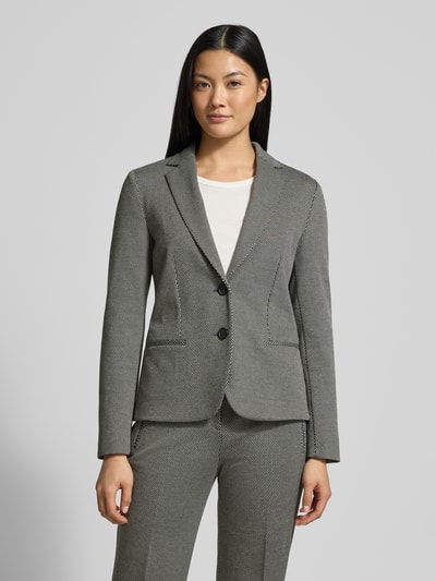 Vrouwenmodel draagt Regular Fit Blazer uit viscosemix Model 'JONALAHRA' van BOSS met all-over motief, 2-knoopsluiting, lange mouw, travel friendly, wrinkle recovery, machinewas, 4-weg stretch, stretchmateriaal, zakdetails, voorkant zicht, borst en taille; Nahaufnahme Oberkörper.