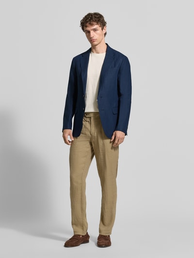 Männermodel trägt Regular Fit Anzugsakko aus reinem Leinen von Polo Ralph Lauren in Dunkelblau mit Reverskragen und Pattentaschen, Ganzkörperansicht von vorne.