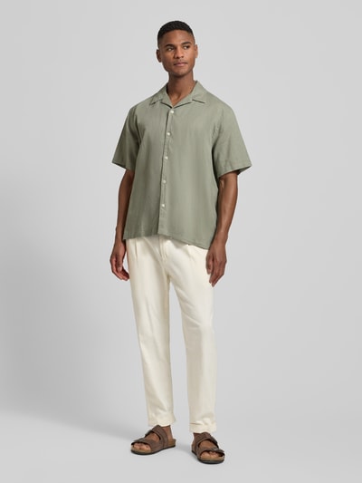 Männermodel trägt Relaxed Fit Bundfaltenhose aus Baumwoll-Mix mit Leinen-Anteil Modell 'LOUIS-W' von Strellson in Melange-Optik, Twillstrukur, helle Farbe, seitliche Reißverschlusstasche, Ganzkörperansicht von vorne.