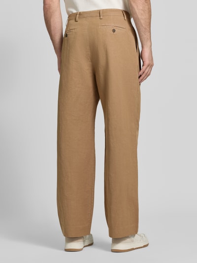 Männermodel trägt Relaxed Fit Stoffhose aus Baumwoll-Leinen-Mix von Paul Smith in Beige mit Kellerfalten, Rückansicht, Ganzkörperansicht. Bundweite 42 cm, Innenbeinlänge 78 cm, Eingriff- und Gesäßtaschen mit Knopf- und Reißverschluss.