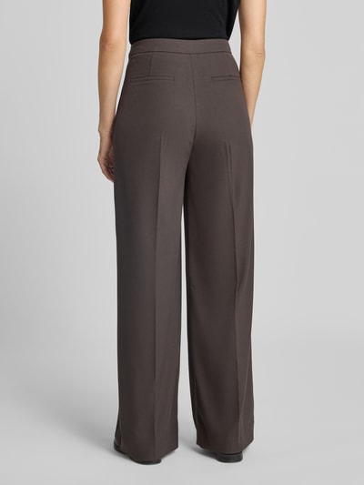 Frauenmodel trägt Relaxed Fit Anzughose mit Viskose-Anteil Modell 'TAILOR' von Cph Muse in Braun, glatte Textur, Ganzkörperansicht Rückansicht.