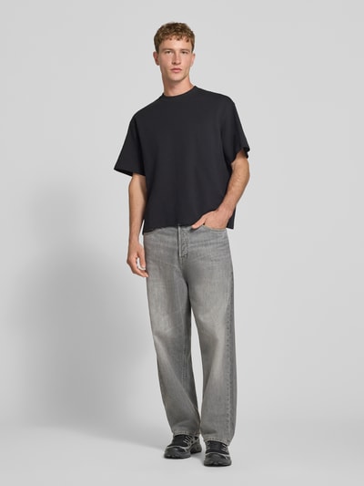 Männermodel trägt Straight Fit Jeans aus reiner Baumwolle im Used-Look von JACK & JONES in Grau, 5-Pocket-Design, Ganzkörperansicht von vorne.
