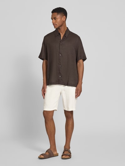 Męski model nosi Leinen Shorts mit Eingrifftaschen Modell 'PANDRUP' od Casual Friday z lnu, krój straight fit, gładka faktura, cała sylwetka z przodu.