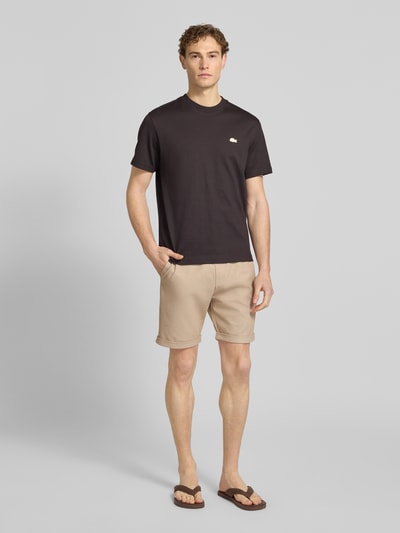 Männermodel trägt Shorts mit elastischem Bund und Gesäßtasche von MCNEAL, beige Farbe, Regular Fit, Ganzkörperansicht von vorne.
