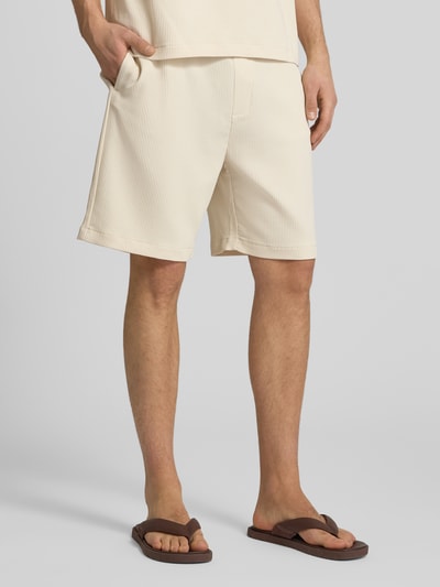 Männermodel trägt Shorts in Plissee-Optik mit elastischem Bund von REVIEW im Regular-Fit aus Material-Mix mit Stretch-Anteil, Nahaufnahme Beinbereich.
