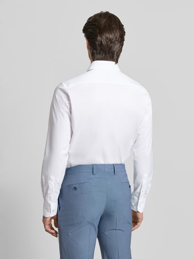 Męski model nosi Slim Fit Businesshemd in Premiumqualität od ETERNA, koszula jednokolorowa, biały, delikatna faktura, krój slim fit, widok całej sylwetki od tyłu.