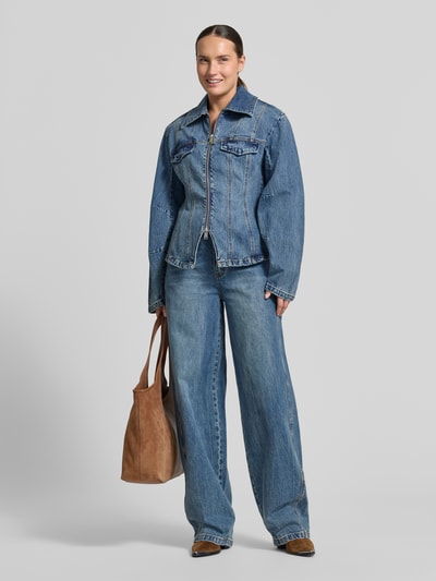 Frauenmodel trägt Jeansjacke aus Baumwoll-Mix Modell 'Melu' von Gestuz in Blau mit Zweiwege-Reißverschluss, Ganzkörperansicht von vorne.