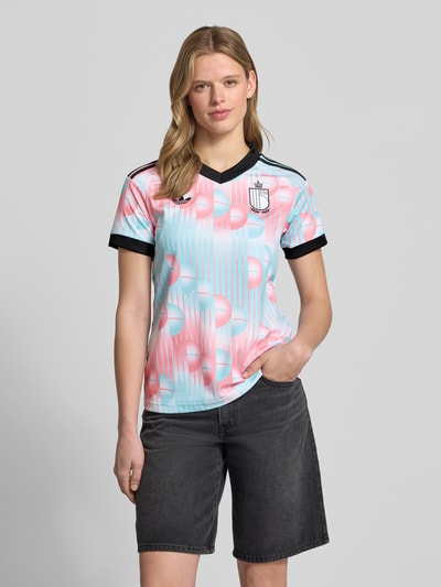 Frauenmodel trägt Damen T-Shirt Trikot mit Logo-Applikation von adidas Sportswear, Optik: Mehrfarbig, Passform: Regular-Fit, V-Ausschnitt, Ärmelform: Kurzarm, Ganzkörperansicht von vorne.