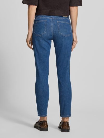 Frauenmodel trägt Slim Fit Jeans mit Eingrifftaschen Modell 'SHAKIRA' von Brax, mittleres Blau, Baumwoll-Mix mit Lyocell, Ganzkörperansicht Rückansicht.