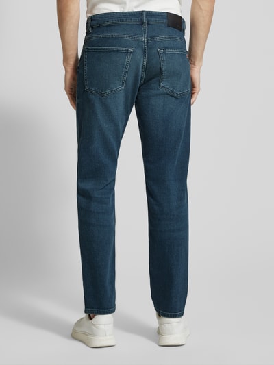 Männermodel trägt Straight Fit Jeans aus Baumwoll-Mix Modell 'RE.MAINE BO CHANGE' von BOSS Orange in klassischem Denim, Ganzkörperansicht Rückansicht.