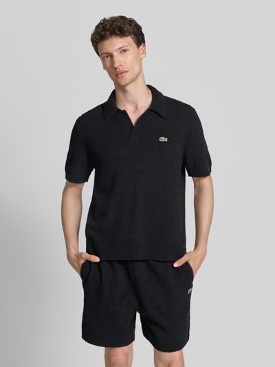 Männermodel trägt Regular Fit Poloshirt aus Baumwoll-Mix von Lacoste, Optik: Unifarben, Label-Patch, Bouclé, Ganzkörperansicht von vorne.