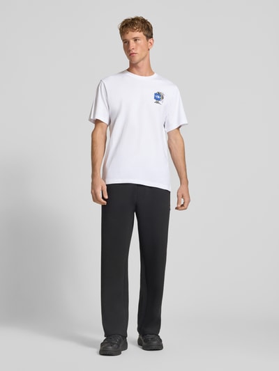 Männermodel trägt T-Shirt aus reiner Baumwolle Modell 'Gear Up Get Out' von The North Face in Weiß mit Logo-Print, Ganzkörperansicht von vorne, Regular Fit, Rundhalsausschnitt, kurzärmelig, Rückenlänge bei Größe M 68 cm.