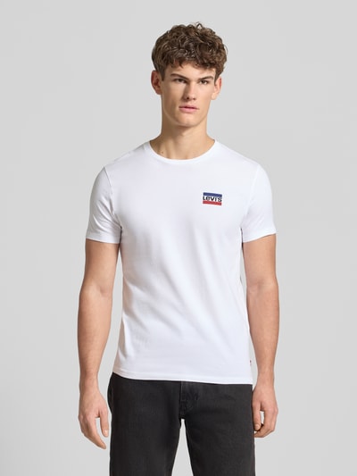 Męski model nosi T-Shirt mit Label-Print im 2er-Pack od LEVI'S®, biała bawełna, krój slim fit, okrągły dekolt, zestaw 2 szt., przód, ujęcie całej sylwetki.