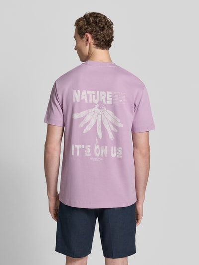 Męski model nosi Relaxed Fit T-Shirt aus reiner Baumwolle von Marc O'Polo, efekt: jednolity kolor, krój regular fit, nadruk z logo, nadruk z motywem, okrągły dekolt, krótki rękaw, wykończenie materiału: dżersej, materiał: czysta bawełna, widok całej sylwetki od tyłu.