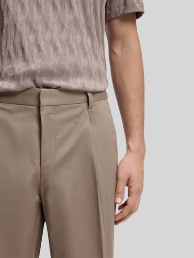 Männermodel trägt Slim Fit Bundfaltenhose aus Baumwoll-Mix Modell 'GENRICH' von HUGO, Optik: Unifarben, Nahaufnahme Oberkörper.