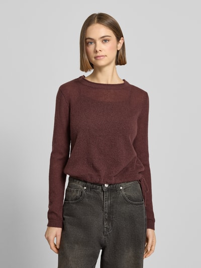 Kobiece model nosi Rundhals Pullover mit Tunnelzug od Review, bordowy kolor, luźny krój, prążkowane wykończenia, widok całej sylwetki z przodu.