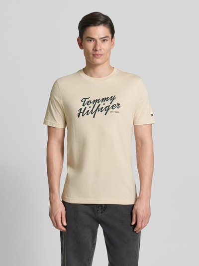 Männermodel trägt Regular Fit T-Shirt aus reiner Baumwolle von Tommy Hilfiger, unifarben, Rundhals, kurzarm, Label Print, Ganzkörperansicht von vorne.