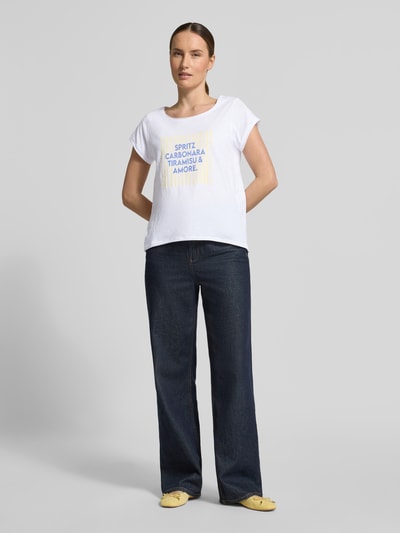 Frauenmodel trägt T-Shirt mit Statement-Print von Christian Berg Woman in Weiß, Reine Baumwolle, Regular-Fit, Rundhalsausschnitt, Rollsaum, Rückenlänge bei Größe S 60 cm, Ganzkörperansicht von vorne