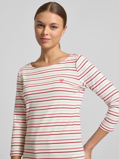 Vrouwenmodel draagt Regular Fit 3/4-Shirt uit katoenmix van Tom Tailor met all-over gestreept patroon en printapplicatie, bootshals, driekwartsmouwen, close-up bovenlichaam.