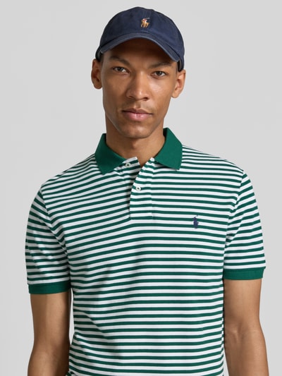 Männermodel trägt Slim Fit Poloshirt aus reiner Baumwolle Modell 'YD MESH STRIPE POLO' von Polo Ralph Lauren in grün-weißen Streifen, Nahaufnahme Oberkörper.