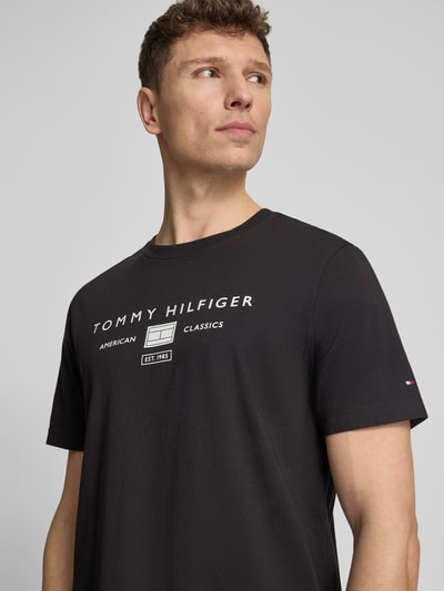 Männermodel trägt Regular Fit T-Shirt aus reiner Baumwolle von Tommy Hilfiger, Optik: Unifarben, Label-Print, Rundhals, Kurzarm, Nahaufnahme Oberkörper.